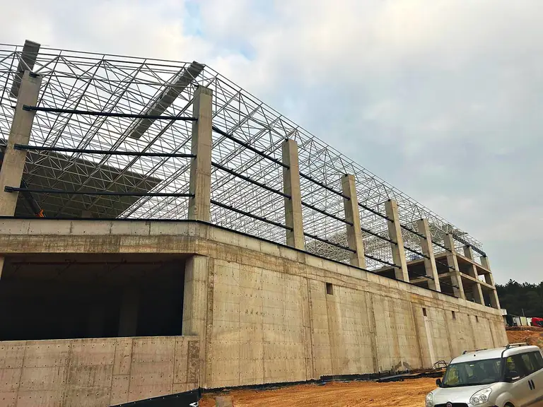 Beton gövde üzerinde boydan boya uzanan uzay kafes çatı