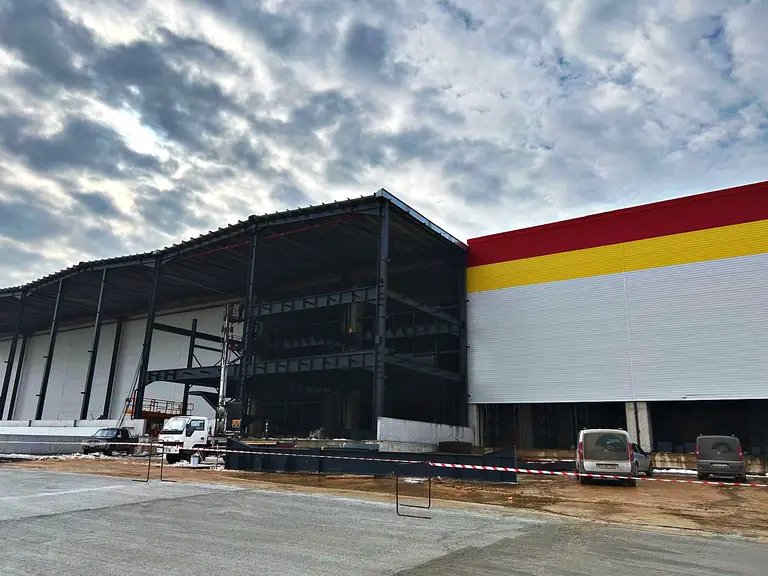 Sandviç panel cephe ve önünde yükselen katlı çelik yapı